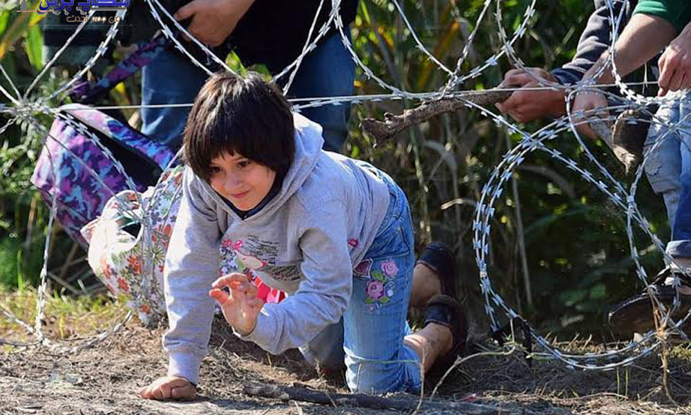 طفلة تعبر سياج حدودي بالاسلاك الشائكة مع اسرتها المهاجرة الى اوروبا.. شاهد الصور