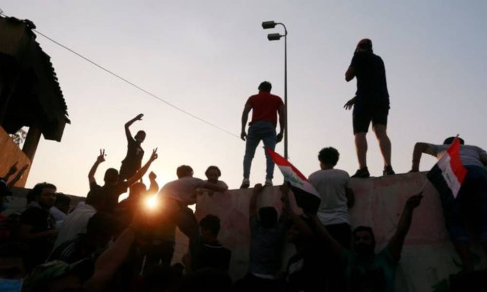 بالفيديو .. متظاهر "يتسلق" سيارة وزير المالية في البصرة