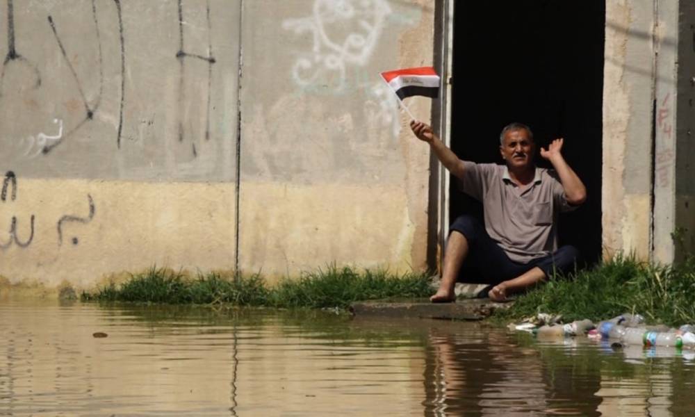 بالصور .. بعد مياه الامطار مياه "المجاري" تغرق البيوت ..  والاهالي يسخرون برفع العلم !